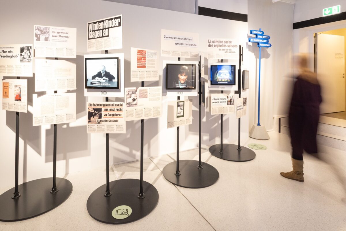 Ständer mit Bildern von Zeitungsausschnitten und Bildschirmen